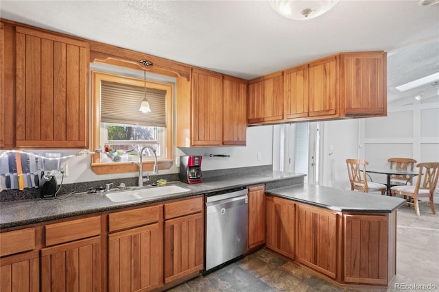 kitchen featuring pendant lighting, sink, stainless steel dishwasher, and a textured ceiling