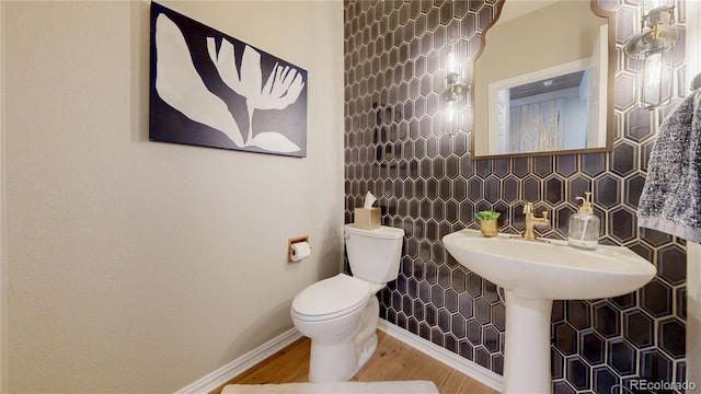 bathroom featuring toilet, baseboards, and wood finished floors