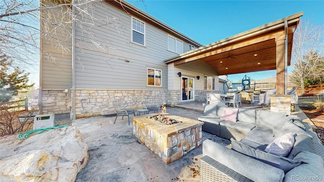 view of patio / terrace with an outdoor living space with a fire pit and a ceiling fan