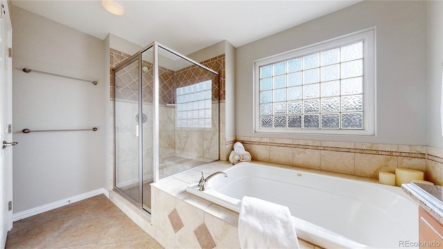 full bathroom featuring a garden tub, a stall shower, and tile patterned flooring