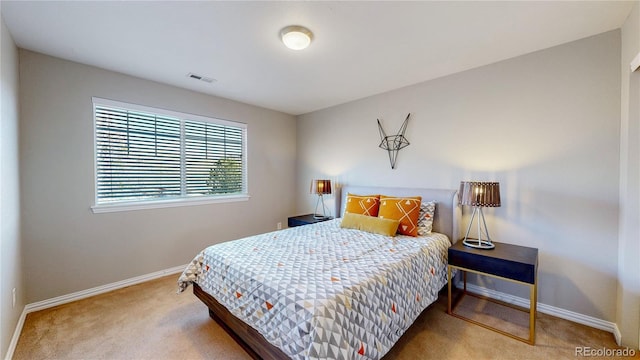 carpeted bedroom featuring visible vents and baseboards