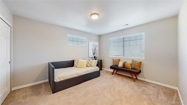 sitting room with visible vents, baseboards, and light colored carpet