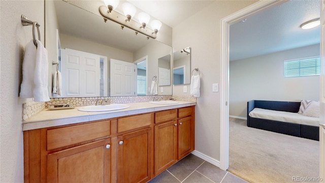 bathroom with tile patterned floors, double vanity, baseboards, and a sink