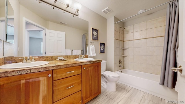 full bath featuring double vanity, toilet, shower / bath combo with shower curtain, and a sink