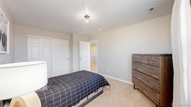 bedroom featuring light carpet, visible vents, baseboards, and a closet