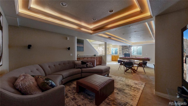 living room featuring light colored carpet, crown molding, a raised ceiling, and baseboards