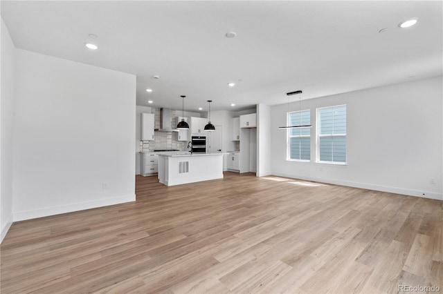 223 Washington St, Erie, CO 80516 - unfurnished living room with light wood finished floors, recessed lighting, and baseboards
