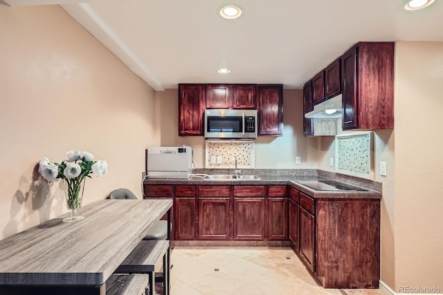 11803 E 114th Pl, Commerce City, CO 80640 - kitchen with stainless steel microwave, under cabinet range hood, black electric cooktop, dark brown cabinets, and recessed lighting