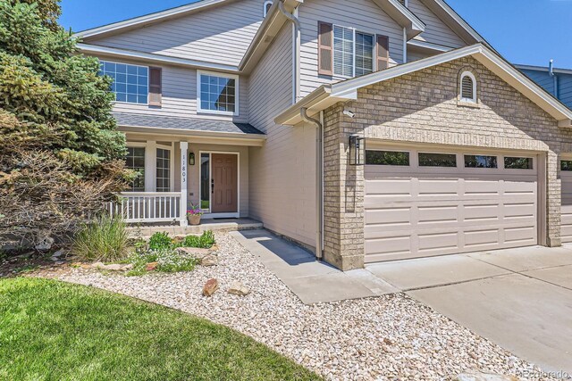 11803 E 114th Pl, Commerce City, CO 80640 - traditional-style house featuring a porch, a garage, and concrete driveway