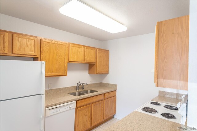 kitchen with sink, light tile patterned floors, and white appliances