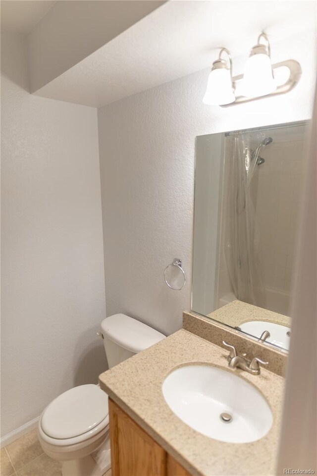 bathroom with tile patterned floors, walk in shower, vanity, and toilet