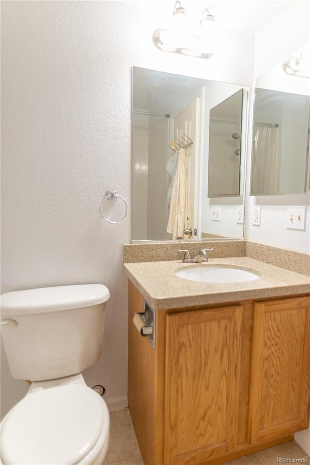 bathroom featuring tile patterned floors, vanity, and toilet