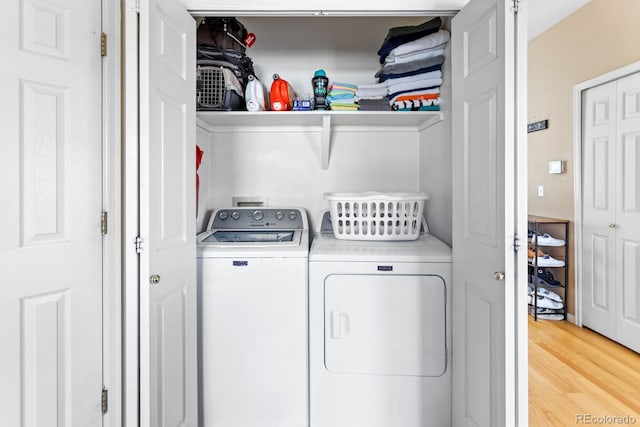 laundry room featuring light wood-style floors, laundry area, and separate washer and dryer