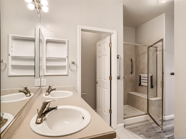 bathroom with double vanity, a sink, and a shower stall