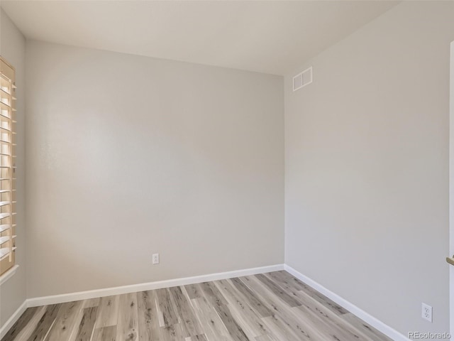 spare room with visible vents, light wood finished floors, plenty of natural light, and baseboards