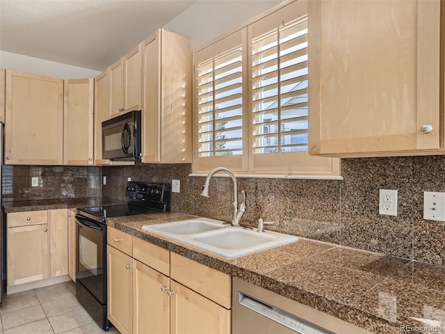 kitchen featuring decorative backsplash, light brown cabinetry, a sink, black appliances, and tile counters