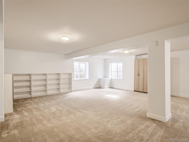 below grade area with baseboards and light carpet
