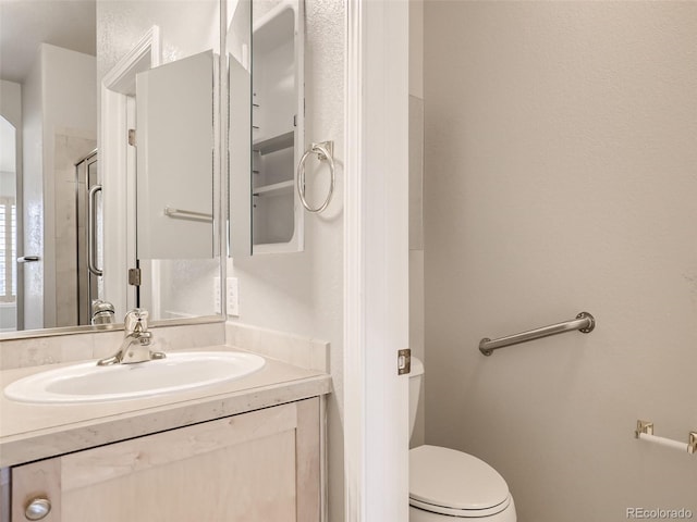full bathroom featuring an enclosed shower, vanity, and toilet