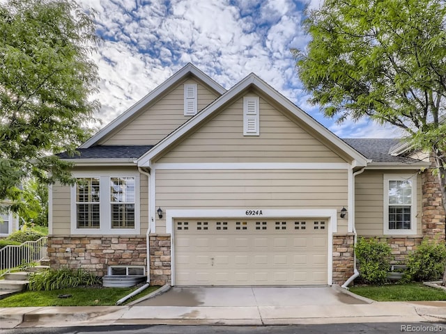 craftsman inspired home with concrete driveway, a shingled roof, and stone siding