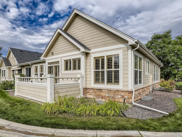 rear view of property featuring stone siding