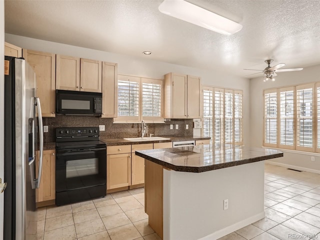 kitchen with light brown cabinetry, tasteful backsplash, a sink, light tile patterned floors, and black appliances