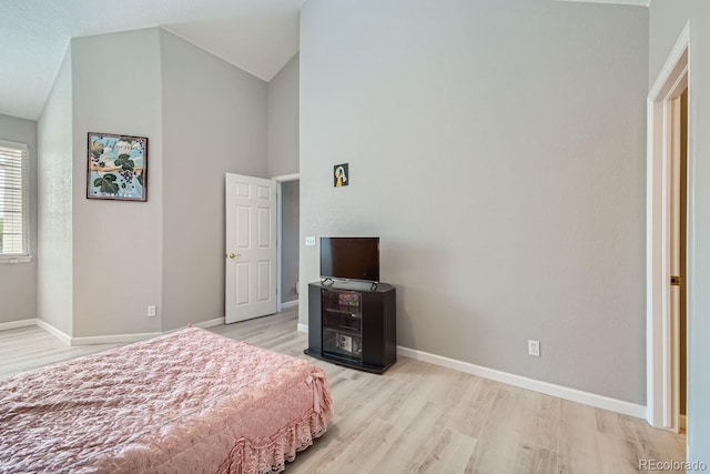 22580 E Ontario Dr Unit 202, Aurora, CO 80016 - bedroom featuring light wood-style floors, baseboards, and high vaulted ceiling