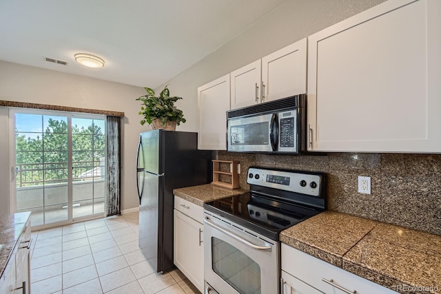 kitchen featuring light tile patterned flooring, appliances with stainless steel finishes, white cabinets, and decorative backsplash