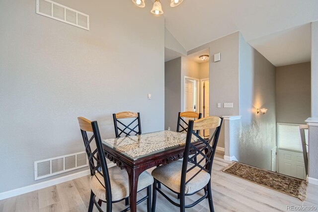 dining room featuring lofted ceiling and light hardwood / wood-style flooring