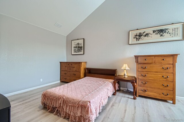 bedroom with lofted ceiling and light wood-type flooring