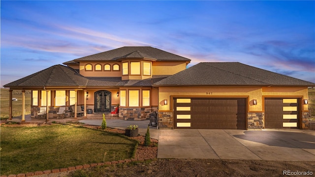 942 S County Road 129th Rd, Bennett, CO 80102 - view of front of property featuring stone siding, stucco siding, concrete driveway, an attached garage, and a porch