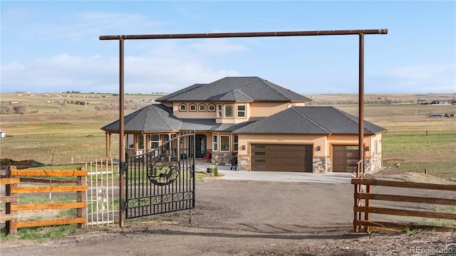 942 S County Road 129th Rd, Bennett, CO 80102 - prairie-style house featuring fence, stone siding, a garage, dirt driveway, and a gate