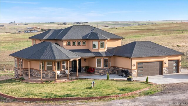 942 S County Road 129th Rd, Bennett, CO 80102 - view of front facade with stucco siding, an attached garage, driveway, and stone siding
