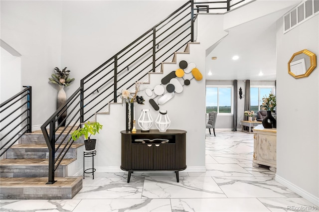 942 S County Road 129th Rd, Bennett, CO 80102 - staircase featuring baseboards, visible vents, a towering ceiling, and marble finish floor
