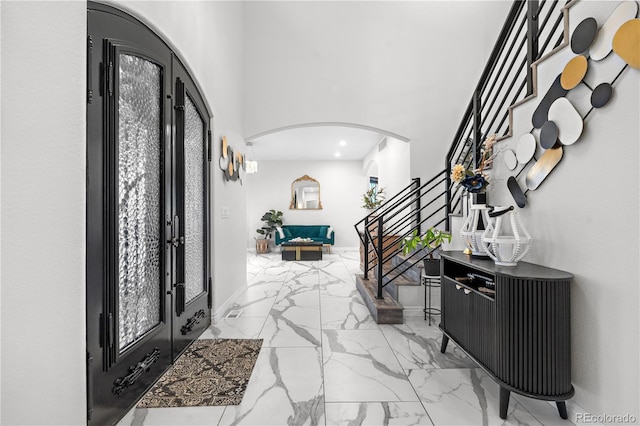 942 S County Road 129th Rd, Bennett, CO 80102 - entryway featuring marble finish floor, a towering ceiling, stairs, recessed lighting, and arched walkways