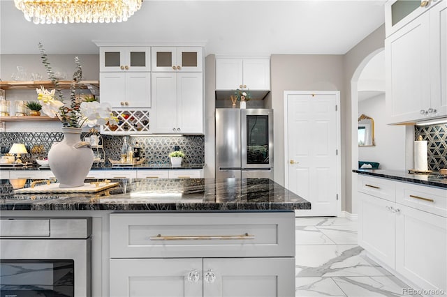 942 S County Road 129th Rd, Bennett, CO 80102 - kitchen featuring arched walkways, smart refrigerator, backsplash, and marble finish floor