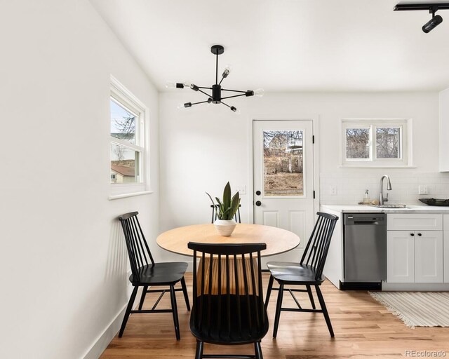 dining room with light wood-style floors, baseboards, and a notable chandelier