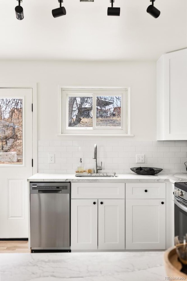 kitchen featuring stainless steel appliances, plenty of natural light, a sink, and backsplash