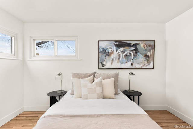 bedroom with baseboards and wood finished floors