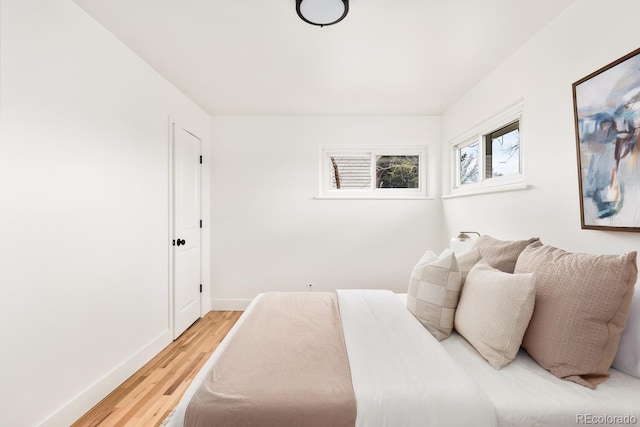 bedroom with light wood-style floors and baseboards