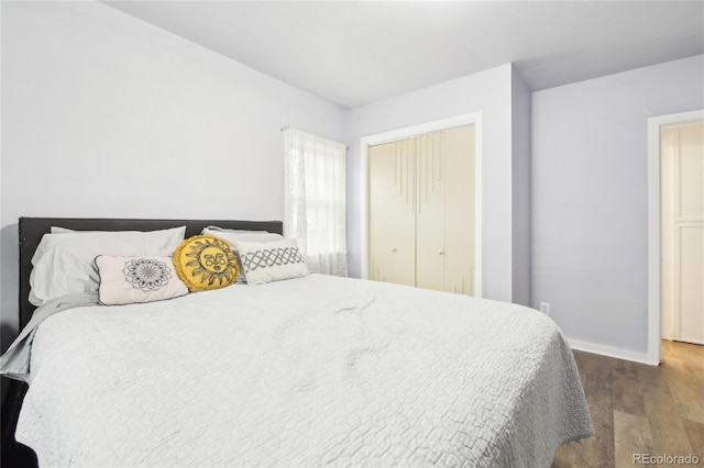 bedroom featuring a closet, baseboards, and wood finished floors