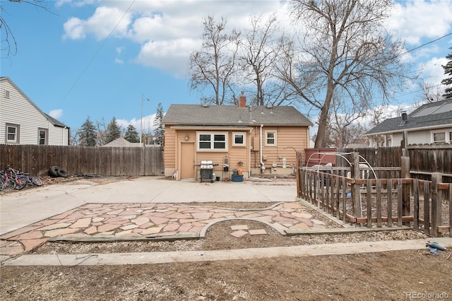 back of house with a fenced backyard, entry steps, a chimney, and a patio