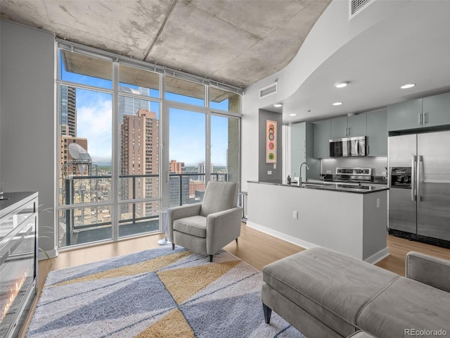 891 14th St Unit 2505, Denver, CO 80202 - living room with light wood finished floors, a city view, baseboards, floor to ceiling windows, and recessed lighting