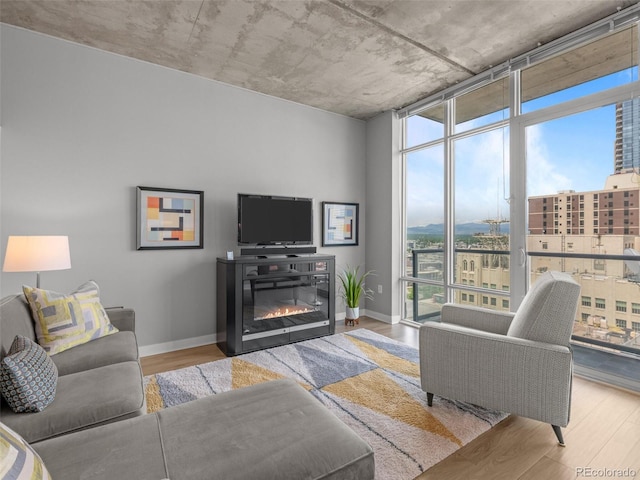 891 14th St Unit 2505, Denver, CO 80202 - living area with wood finished floors, baseboards, a glass covered fireplace, and a wall of windows