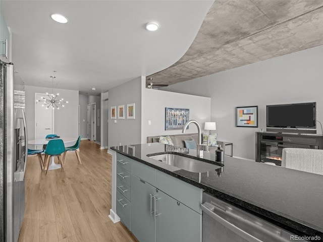 891 14th St Unit 2505, Denver, CO 80202 - kitchen featuring appliances with stainless steel finishes, a sink, open floor plan, light wood-type flooring, and a chandelier