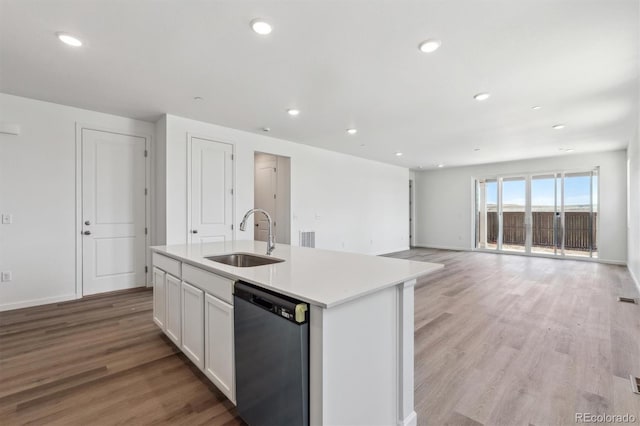 19040 E 96th Pl, Commerce City, CO 80022 - kitchen featuring stainless steel dishwasher, a sink, a center island with sink, white cabinetry, and light wood-type flooring