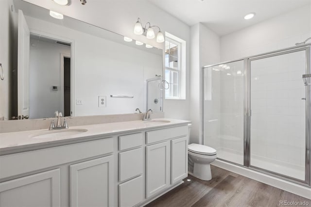19040 E 96th Pl, Commerce City, CO 80022 - full bath with double vanity, toilet, a shower stall, and wood finished floors