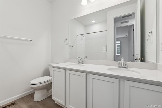 19040 E 96th Pl, Commerce City, CO 80022 - full bathroom featuring toilet, double vanity, wood finished floors, a shower, and baseboards