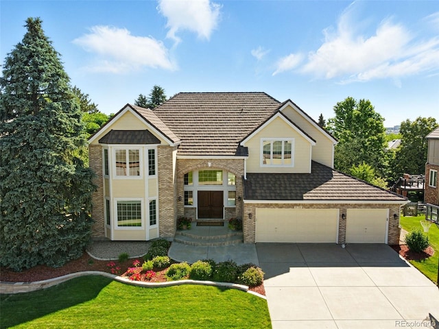 9556 Kemper Dr, Lone Tree, CO 80124 - view of front facade featuring brick siding, concrete driveway, a front yard, and an attached garage