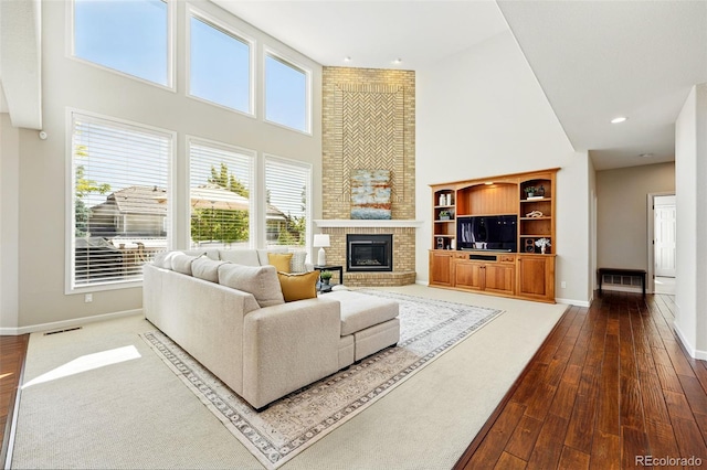 9556 Kemper Dr, Lone Tree, CO 80124 - living room with a towering ceiling, dark wood-type flooring, a fireplace, and recessed lighting
