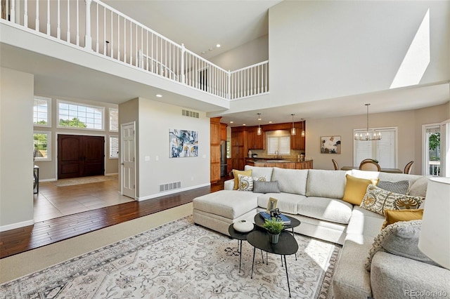 9556 Kemper Dr, Lone Tree, CO 80124 - living room with a high ceiling, a chandelier, healthy amount of natural light, wood finished floors, and recessed lighting